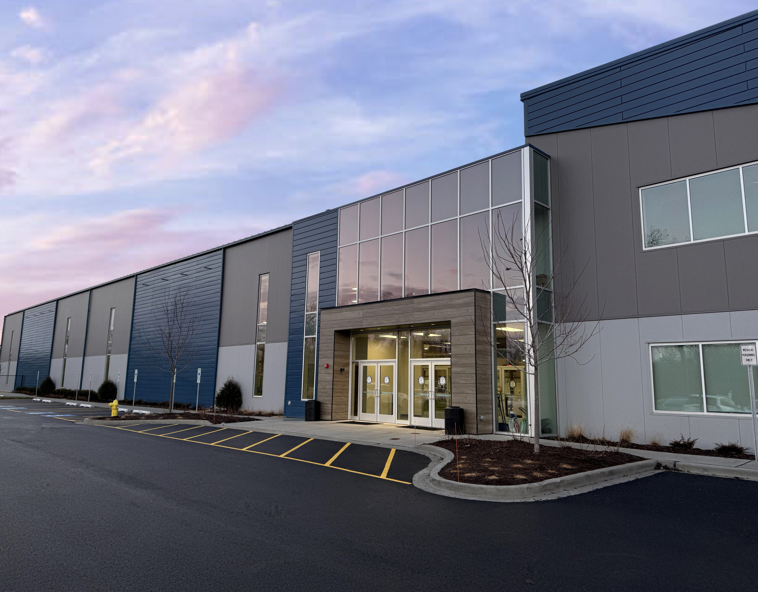 The exterior of Sawmill Sports Hub with a beautiful blue, purple and pink sky.