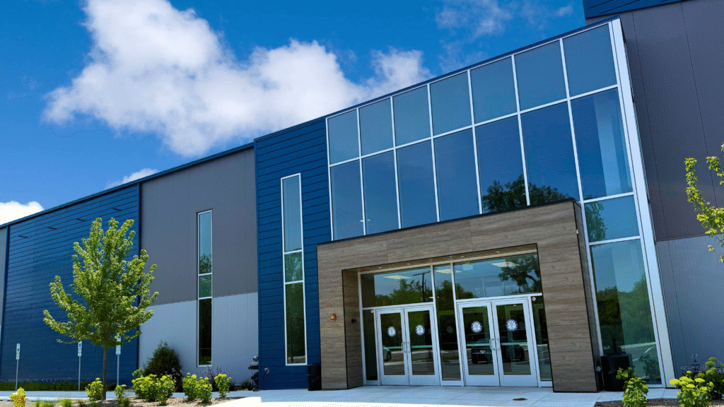 Sawmill Sports Hub exterior facade on a summer day with blue skies and white clouds. The trees outside Sawmill Sports Hub are a crisp green.