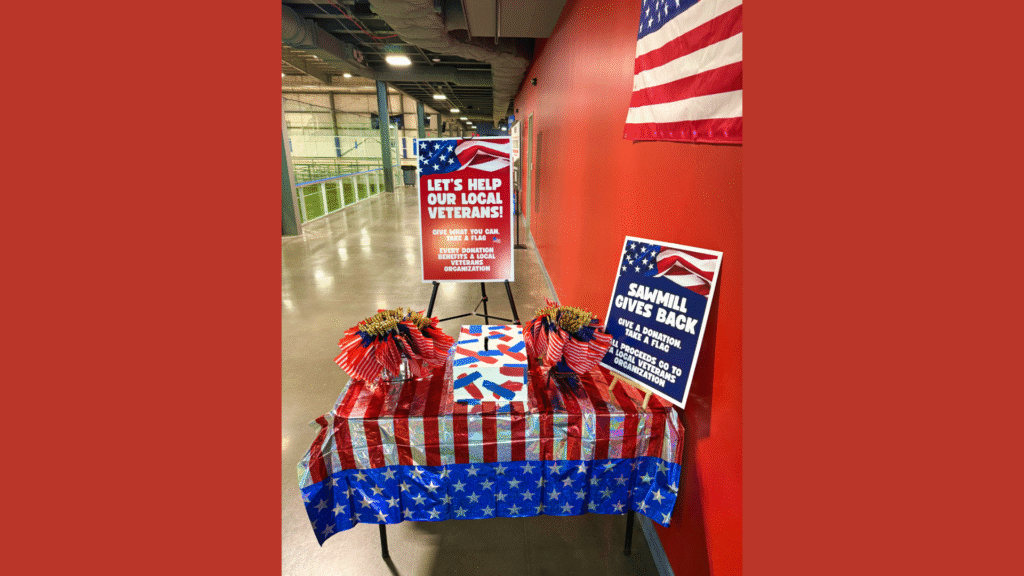 Patriotic display at Sawmill with American flags and donation box for veterans.