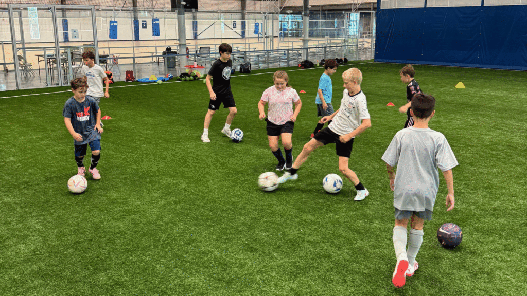 Kids playing indoor soccer on the expansive turf field at Sawmill Sports Hub in Willowbrook, IL.