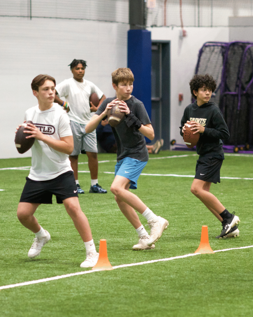 Boys practicing football indoors.