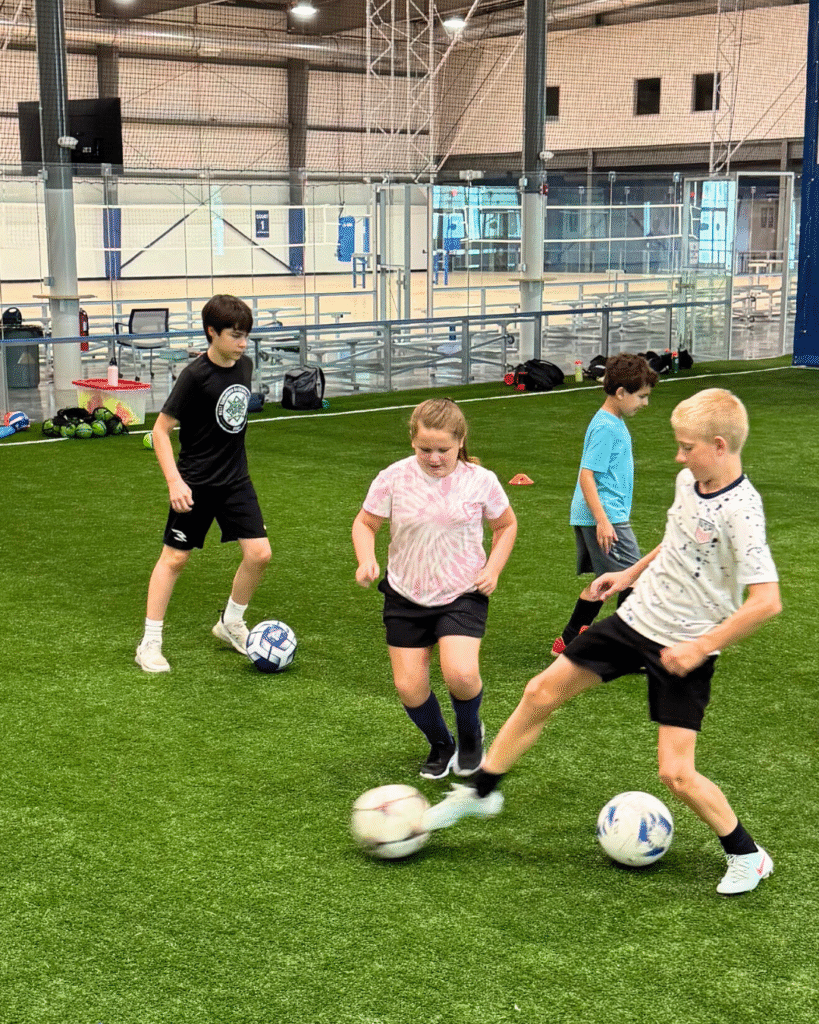 Kids playing soccer on the turf at Sawmill Sports Hub.