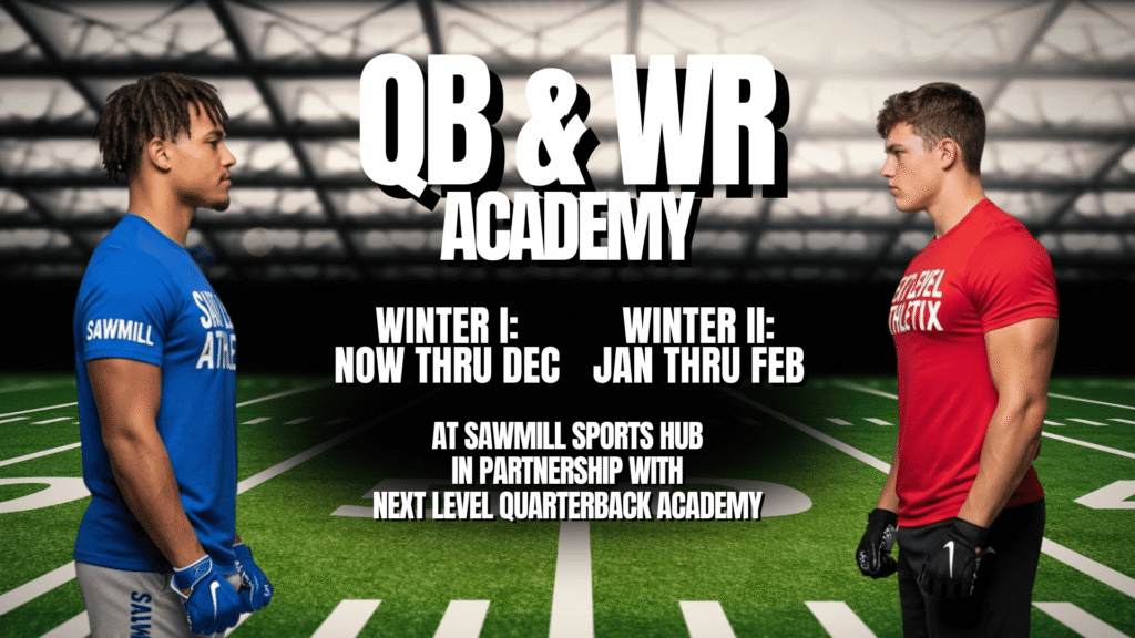 Two football players, a quarterback and a wide receiver, working on skill development drills indoors at the Sawmill Sports Hub. The QB, wearing a blue shirt, is preparing to throw a football to the WR, the other boy in a red shirt, who is running a route.