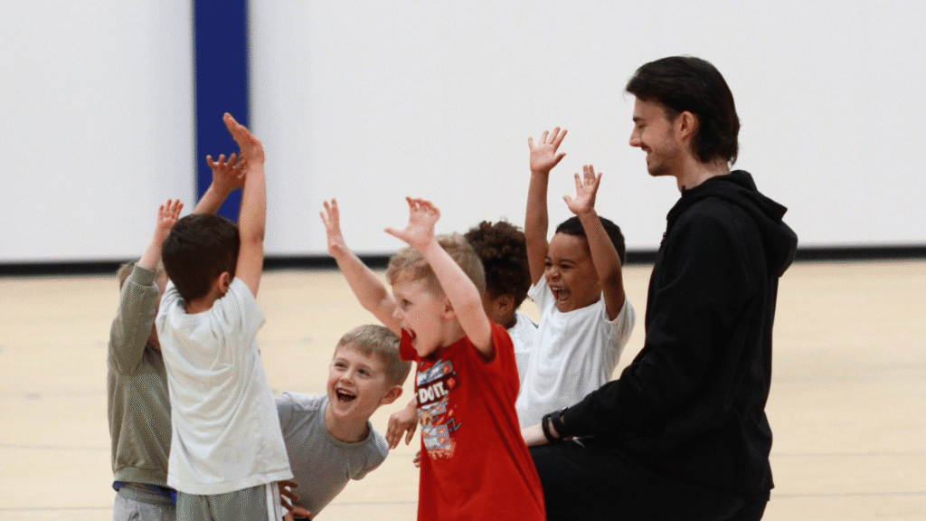 Kids throwing their hands up in celebration and having fun at the Lil' Hoopers class at Sawmill Sports Hub powered by Spartz Sportz.