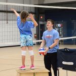 A girl serving a volleyball at Sawmill Sports Hub.